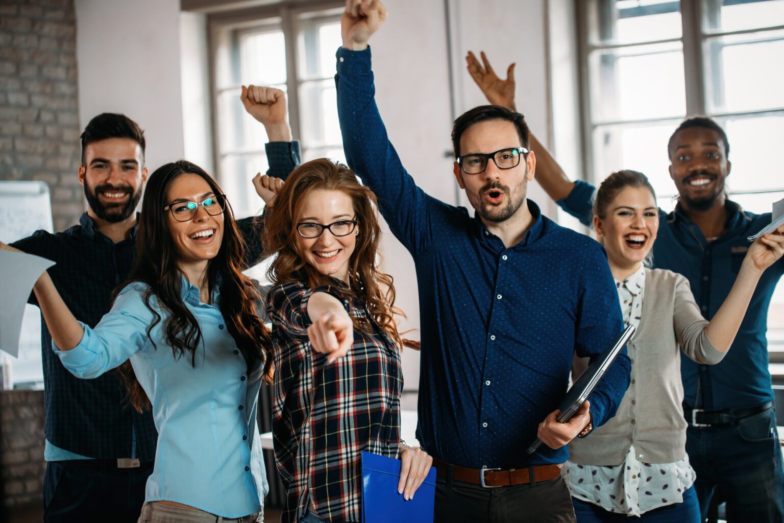 Happy group of successful company employees in office