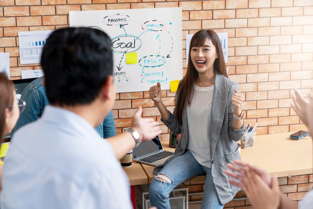 Happy asian creative woman or staff employee feeling enjoy with admires and praise by leadership or boss at small group meeting in creative office workplace. Woman feeling good with smiling face.