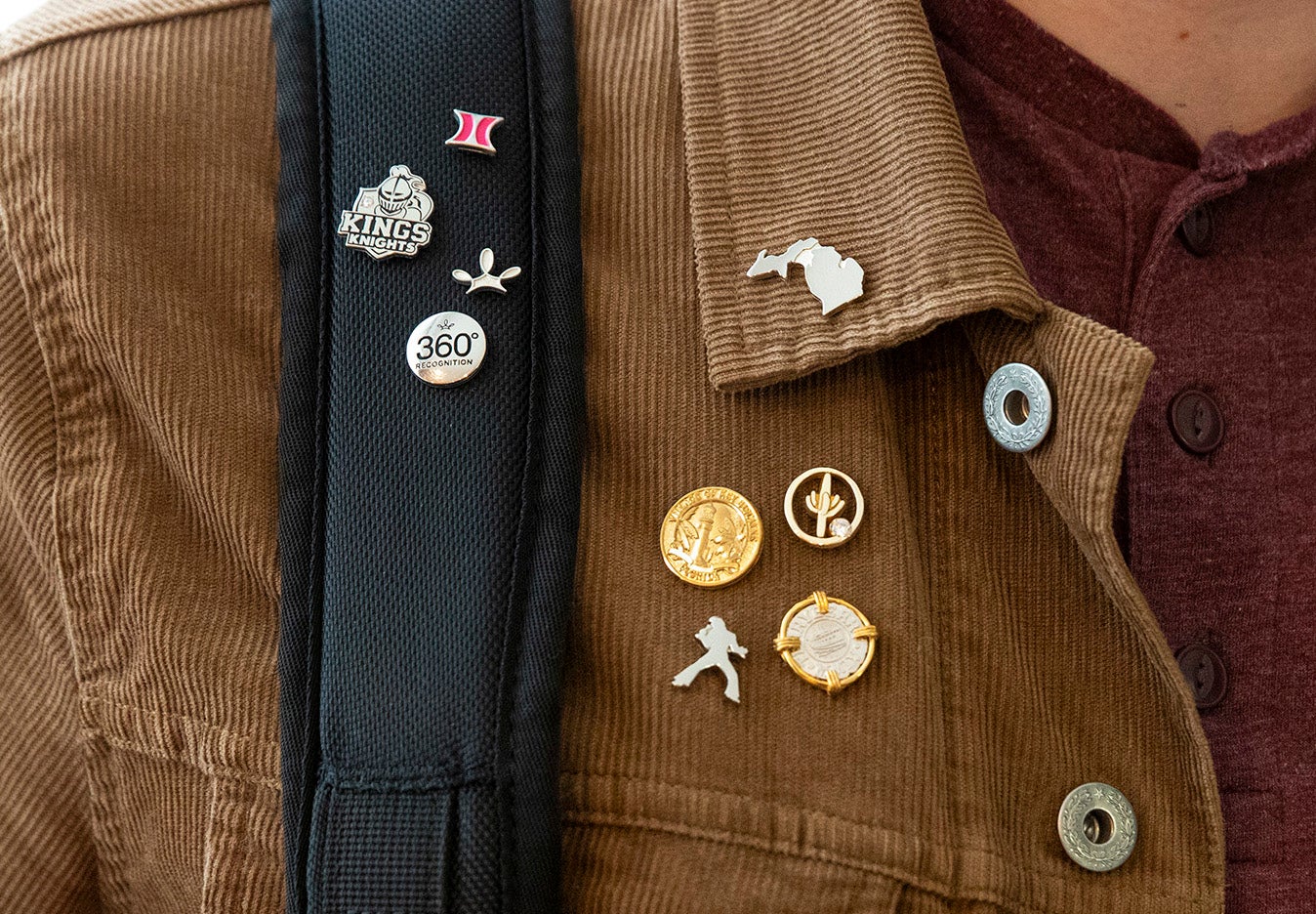 Young man wearing a brown jacket with lapel pins attached