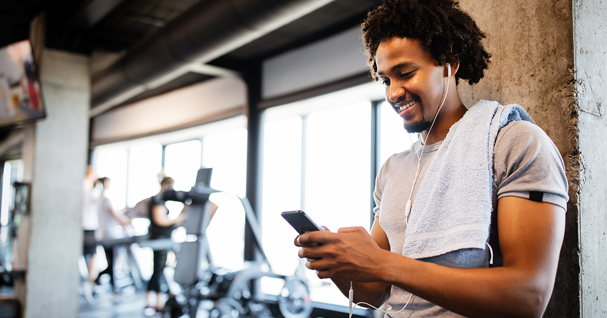 man at gym using phone after workout